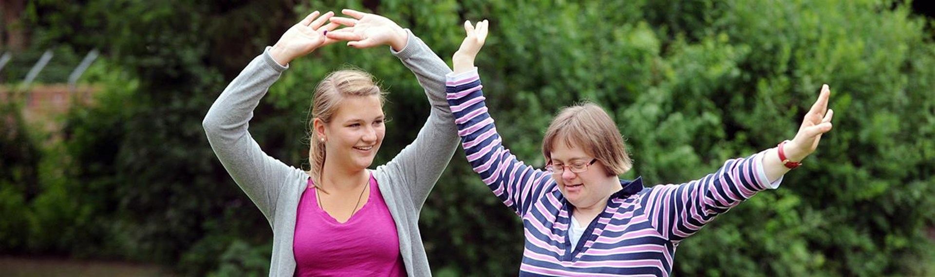 Zwei Frauen, eine mit Trisomie 21, im Garten