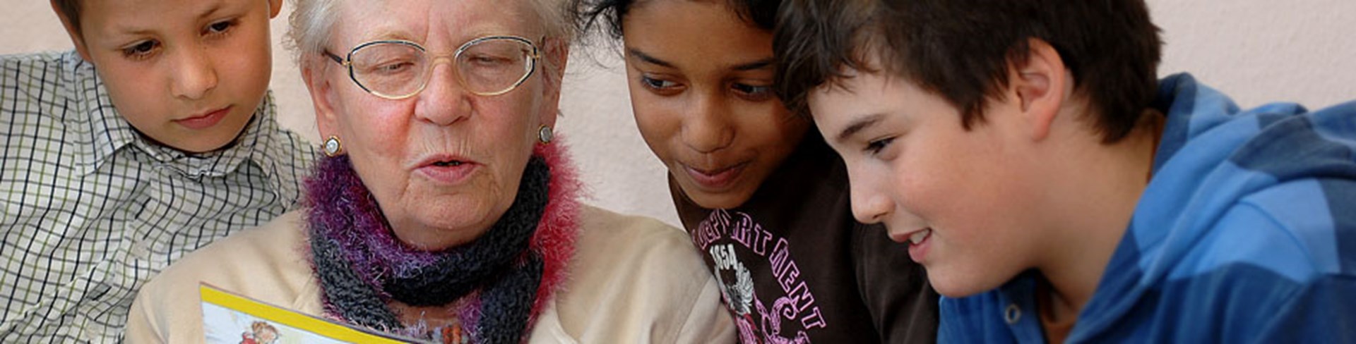 Ältere Frau liest Kindern vor