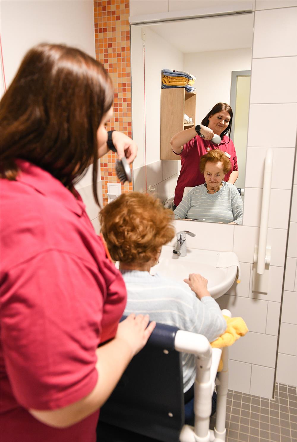 Pflegerin kämmt  Seniorin
