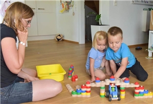 Kita-Kinder beim Spielen Kinder beim Spielen mit Spielzeug. Eine Erzieherin schaut zu.