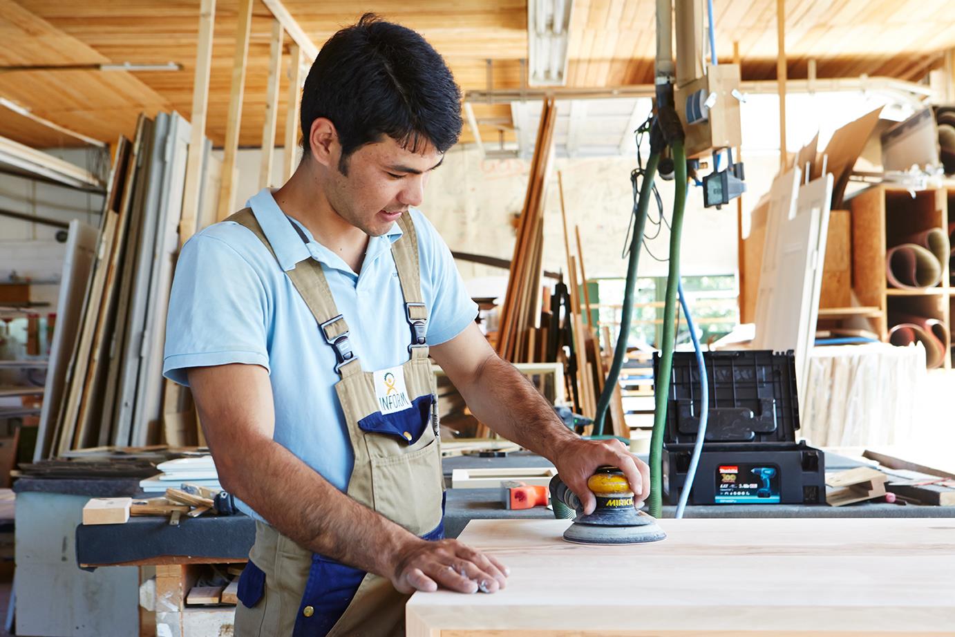 Junger Mann arbeitet in einer Schreinerei.