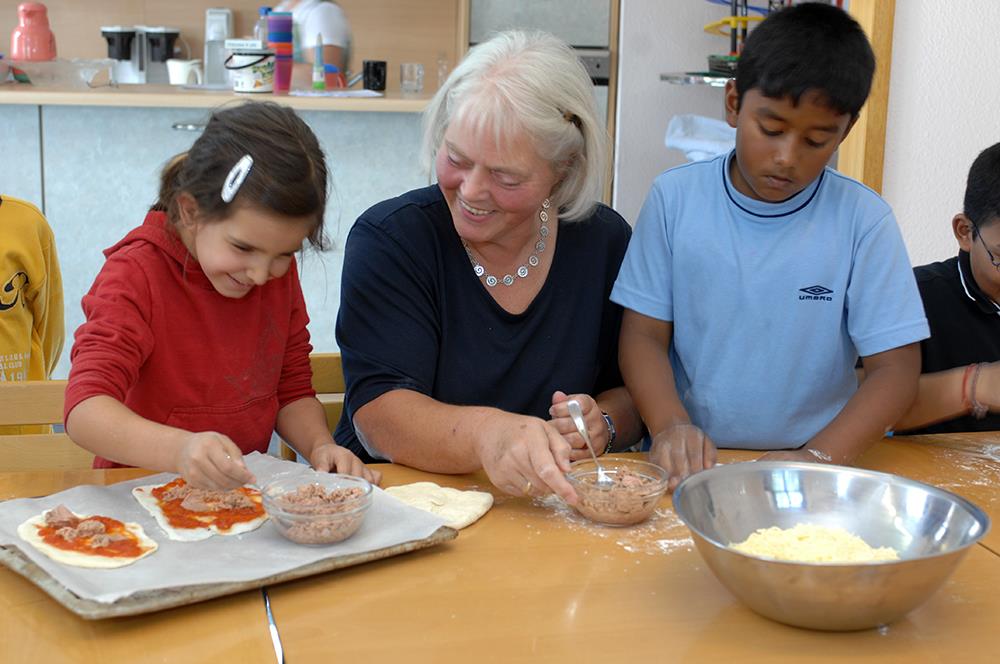 Frau mit Kindern beim Kochen
