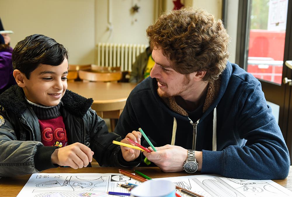 Mann mit Kind in Schulzimmer