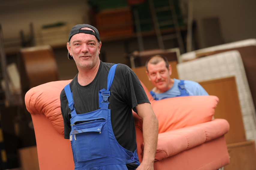 Zwei Männer tragen Sofa