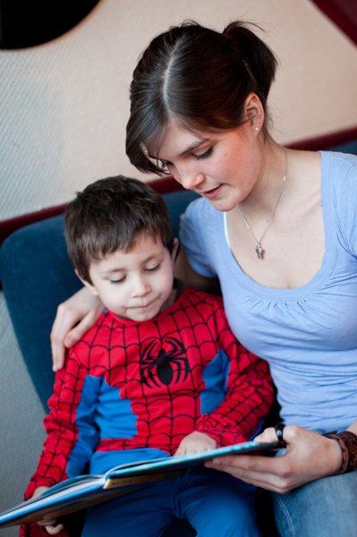 Freiwillige liest einem Jungen etwas vor