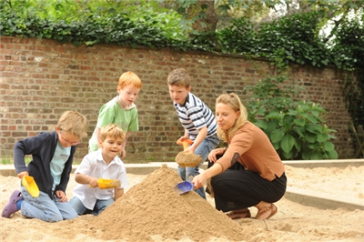 Kinder01 Kinder spielen mit einer Frau im Sand