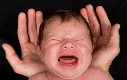 Schreiendes Baby in den Händen der Mutter