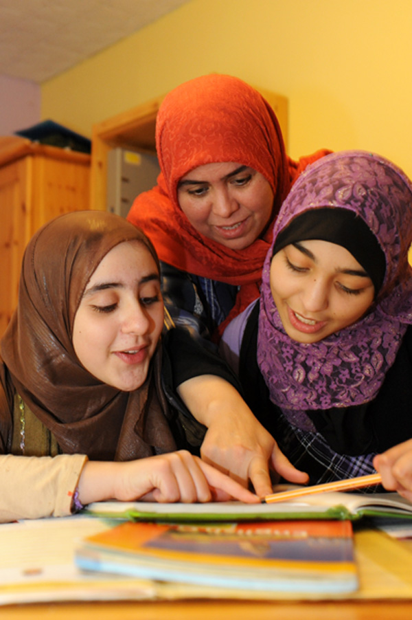 Frauen mit Migrationshintergrund schauen gemeinsam ein Buch an