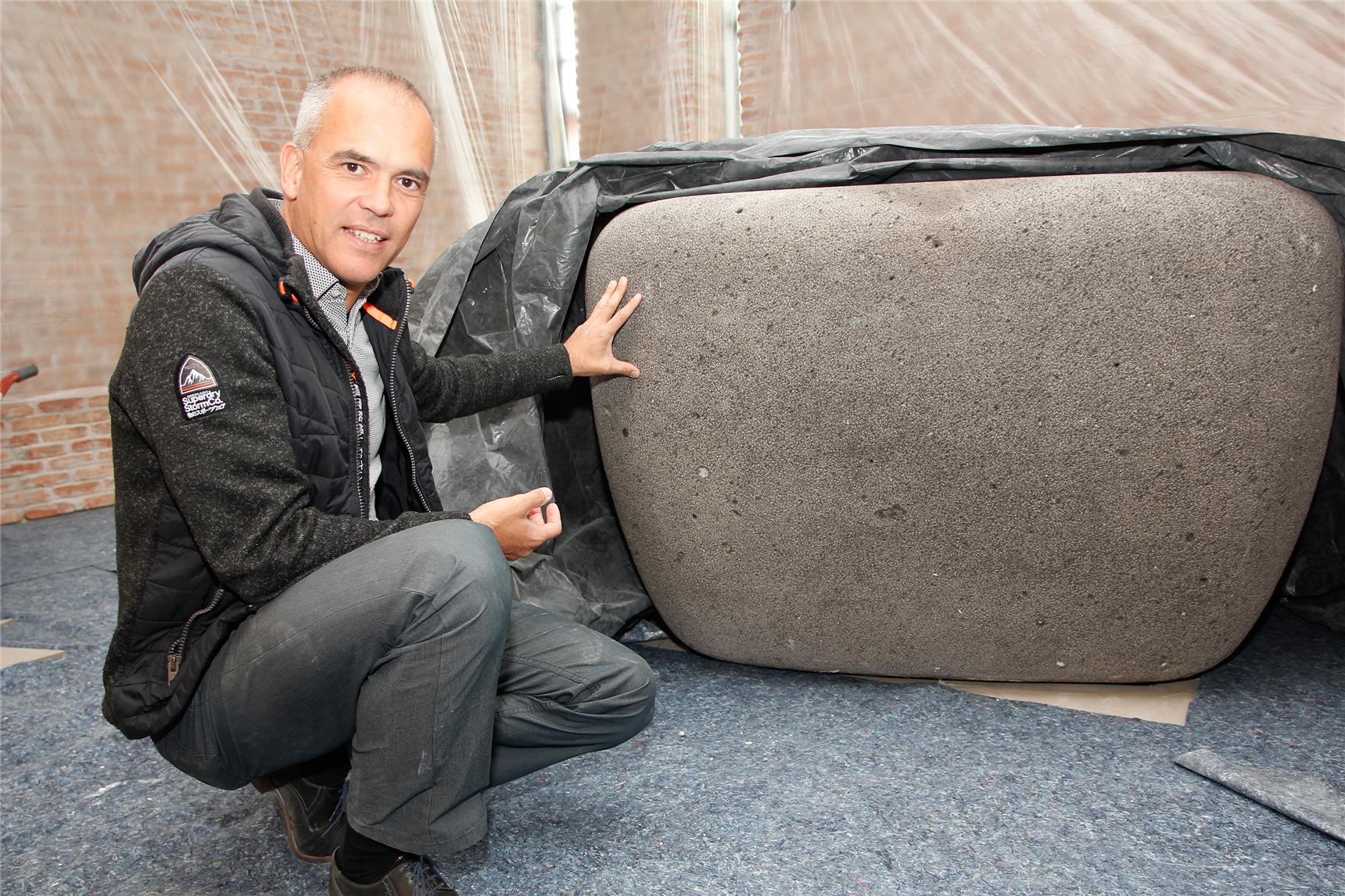 Architekt Christian Taufenbach weist auf die vielen Einschlüsse des Altarsteines aus Basalt hin. Diese Gesteinsart erinnert in mehrfacher Hinsicht an den Lebensweg von Damian de Veuster.