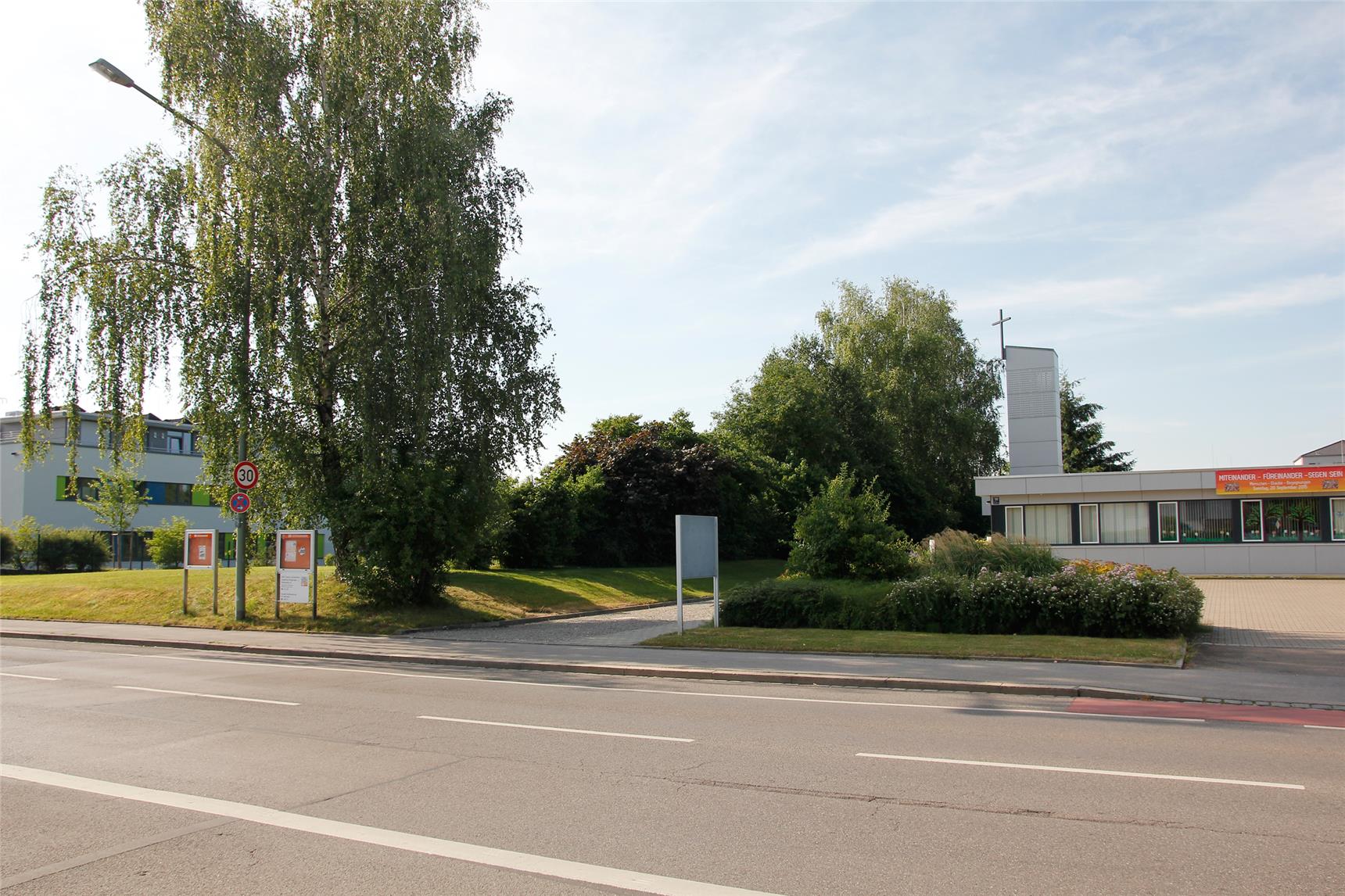Das Grundstück liegt links direkt neben dem Pfarrzentrum der Kuratie St. Johannes Baptist an der Friedrich-Ebert-Straße in Augsburg-Göggingen.