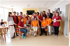 Caritas-Seniorenzentrum St Raphael_Multi-Kulti-Pflegeteam Andreas Bader (4.v.re in der letzten Reihe), Einrichtungsleiter des Caritas-Seniorenzentrums St. Raphael der CAB Caritas Augsburg Betriebsträger gGmbH, und ein Teil seines Multi-Kulti-Pflegeteams.