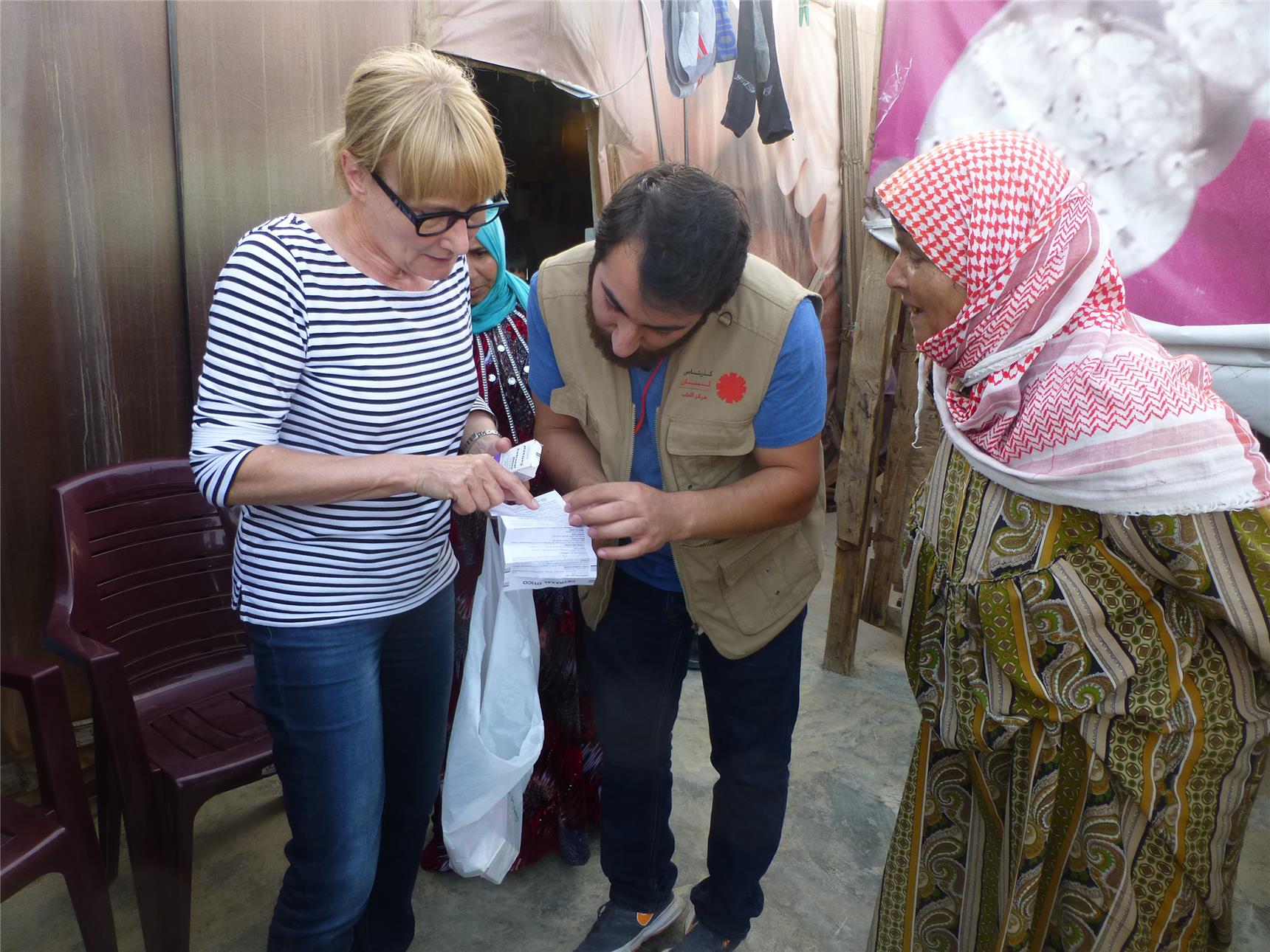 Ein Helfer der Caritas Libanon übersetzt für die  Ärztin Dr. med. Petra Stüberl die Beipackzettel der Medikamente. 