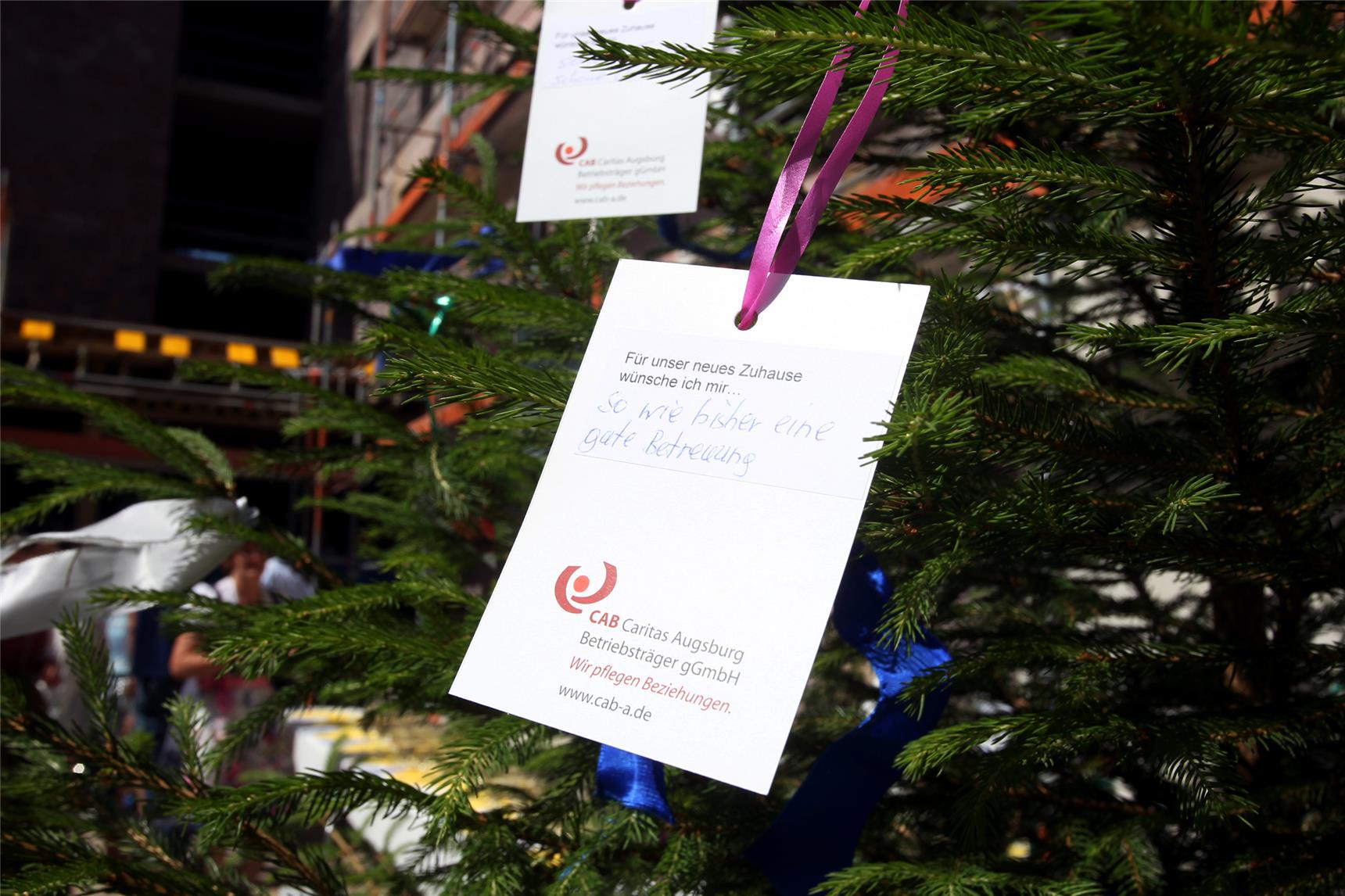 Bewohnerinnen und Bewohner des Heilig-Geist-Spitals, Landsberg, schrieben ihre Wünsche für das neue Seniorenzentrum an der Kommerzienrart-Winklhofer-Straße 3 in Landsberg auf Zettel, die sie dann an den Richtbaum hingen.