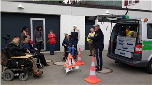 UWA Aichach Förderstätte besucht PI Schwabmünchen Polizeioberkommissar Werner Korn (vorne) zeigte im Beisein von Erstem Polizeihauptkommissar Gernot Hasmüller (im Hintergrund) das Einsatzfahrzeug den Gästen aus der Ulrichswerkstätten Aichach.
