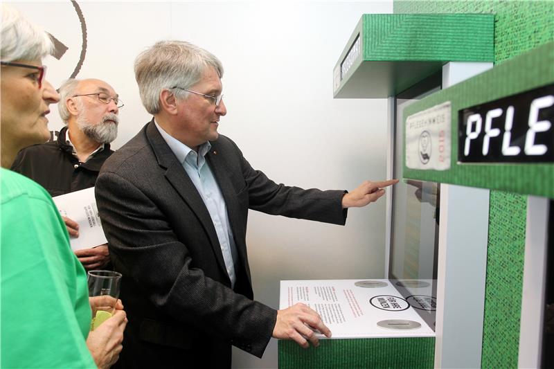 Der Landtagsabgeordnete Harald Güller probierte den Pflegomat aus, an dem man sein Geld wahlweise für menschliches Miteinander oder pflegerische Leistungen ausgeben kann.