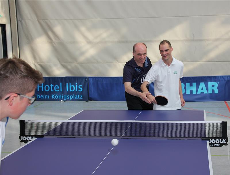 Dieter Voigt (Mitte), stellvertretender Abteilungsleiter der Post SV Telekom, erklärt Markus Schöniger (re.) von den Augsburger Ulrichswerkstätten, wie man den Schläger bei der Vorhand bzw. Rückhand richtig hält, um den Ball gezielt zurückspielen zu können.