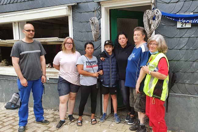 Familie steht vor zerstörtem Haus