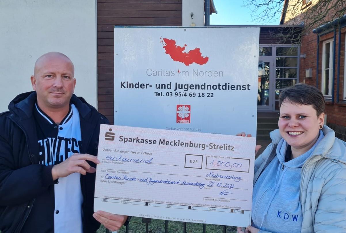 Sarah Görß (KDW) bei der Übergabe des Spendenschecks an Ronny Weber vom Kinder- und Jugendnotdienst