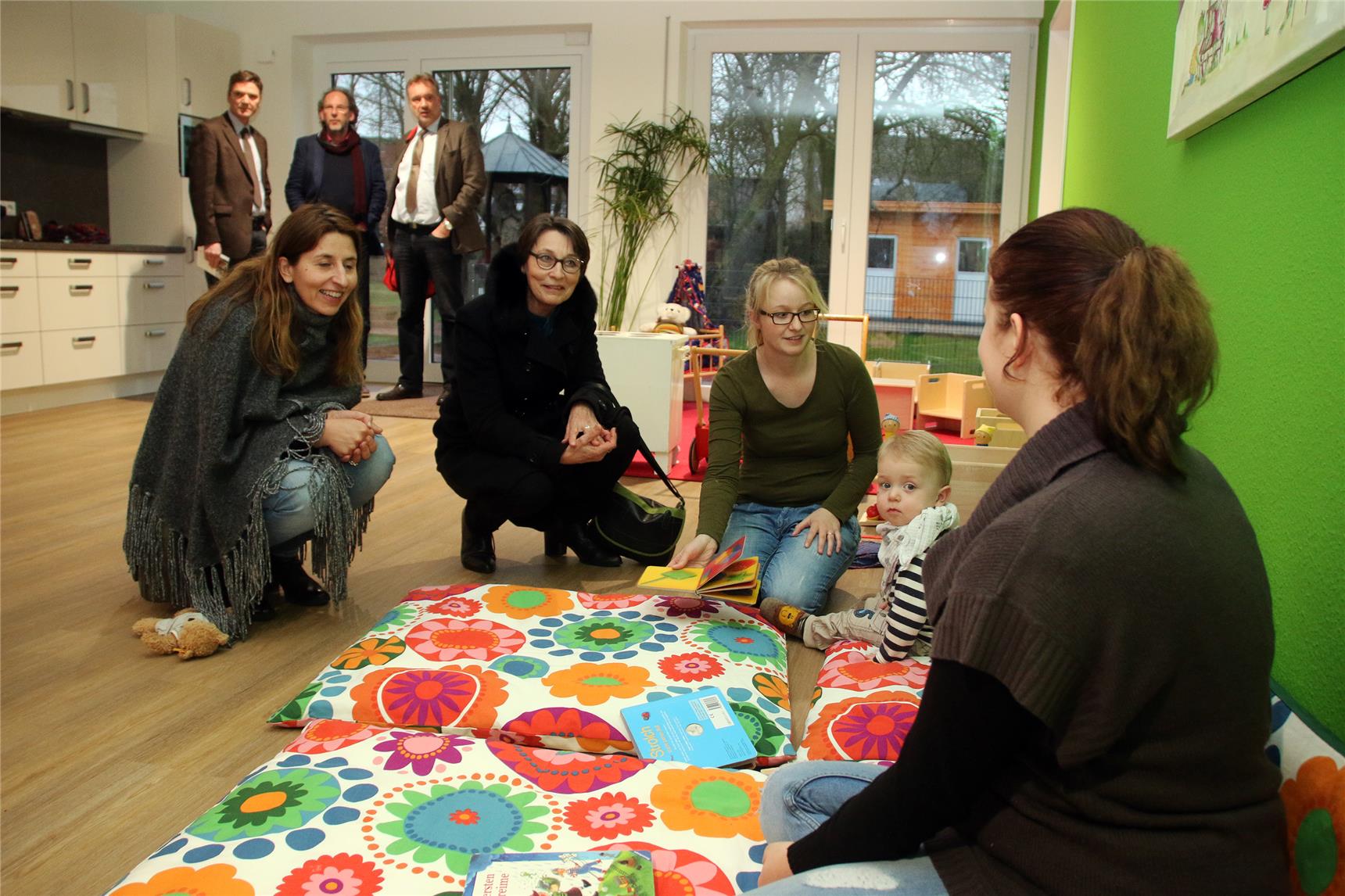 Auf dem Bild knien Teilnehmerinnen vor der Krabbelgruppe
