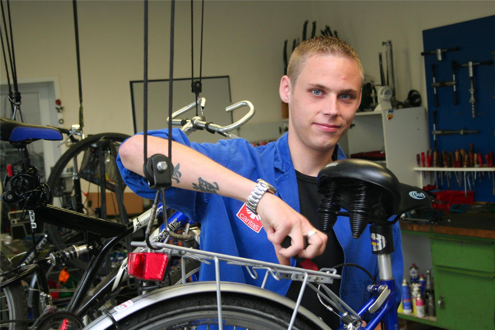 Ein Mann schraubt an einem Fahrradsattel.
