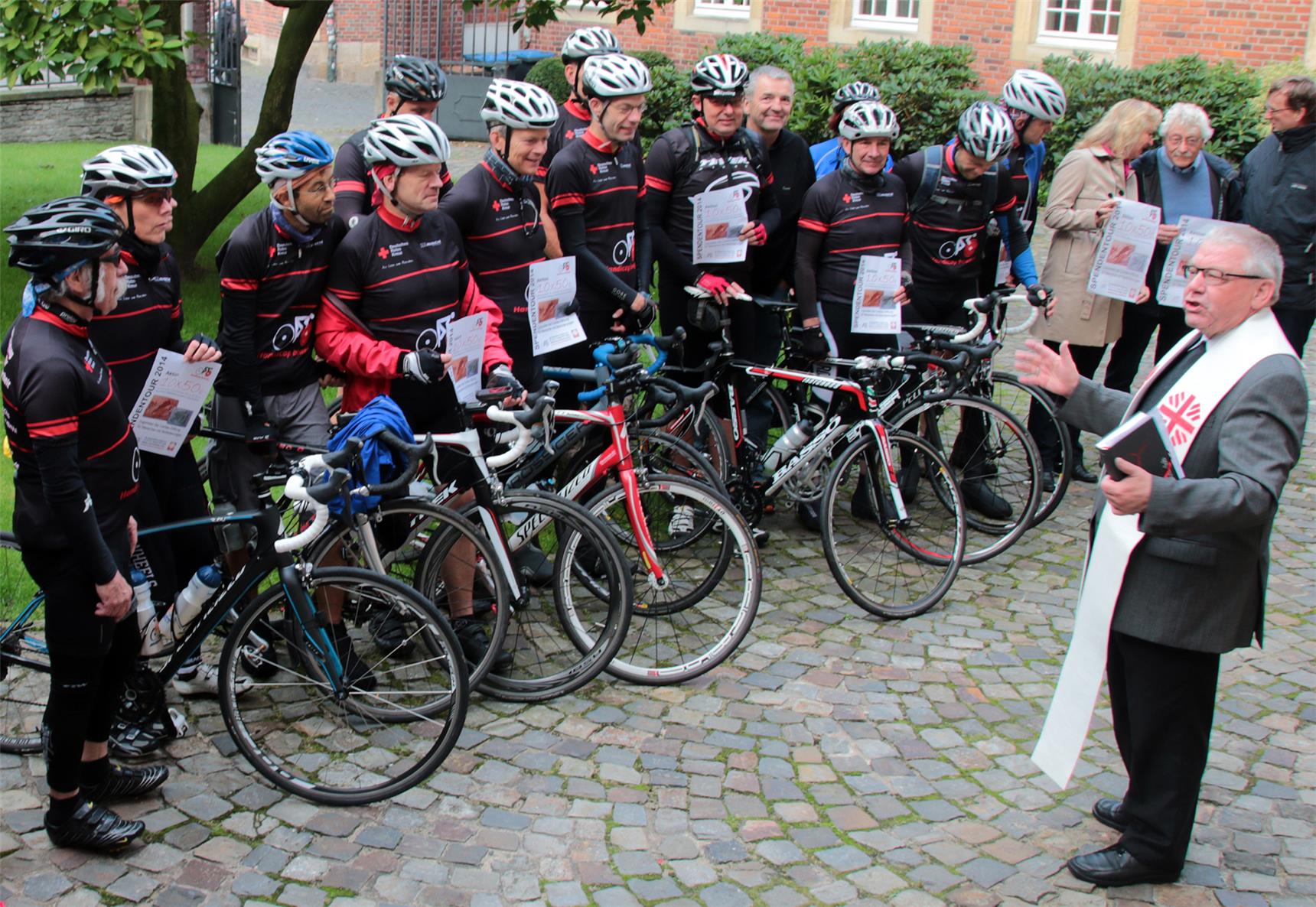 Viele Fahrradfahrer stehen vor dem Weihbischof