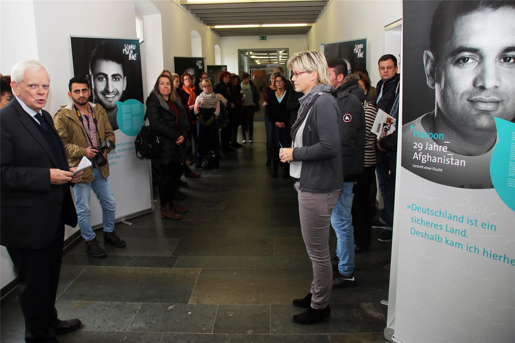 Ein Mann steht vor der Ausstellung und redet.