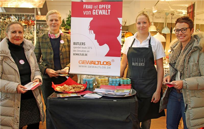  Auf dem Bild sieht man (von links)Gabriele Bongers (Vorstand SkF Recklinghausen), Elisabeth Ochsenfeld (Vorsitzende SkF Recklinghausen), Kathrin Wengen (Fillialleiterin Butlers) und Jutta Weidener (stellvertretende Vorsitzende SkF Recklinghausen) vor dem Infostand in einer Münsteraner Butlers-Filiale um einen Tisch stehen, der auf ihm ein Plakat der Aktion stehen hat. unter dem Plakat sind mehrere Produkte zu sehen.