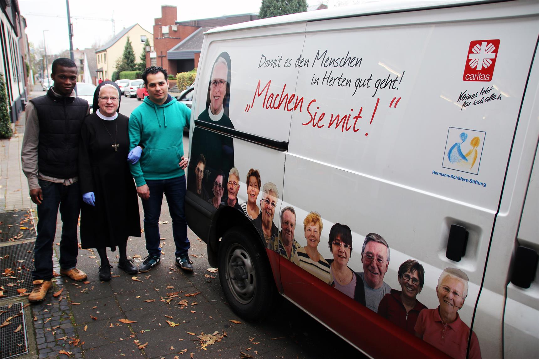 Drei Personen stehen neben einem Bulli.