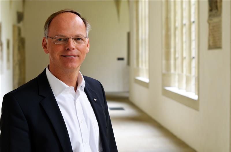 Auf dem Bild ist sieht man Domkapitular Dr. Klaus Winterkamp auf einem Flur stehen.