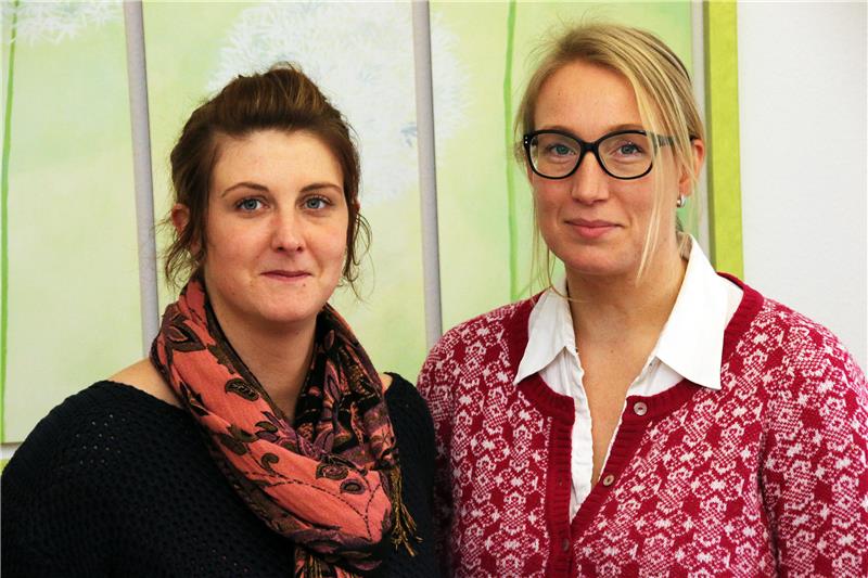 Das Foto zeigt zwei Frauen, die in die Kamera schauen.