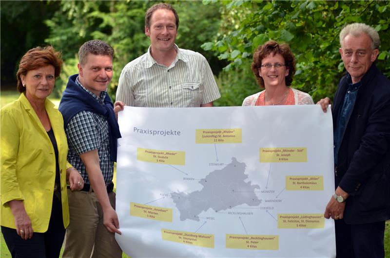 Fünf Personen, zwei Frauen und drei Männer, halten eine Landkarte in Richtung des Betrachters.