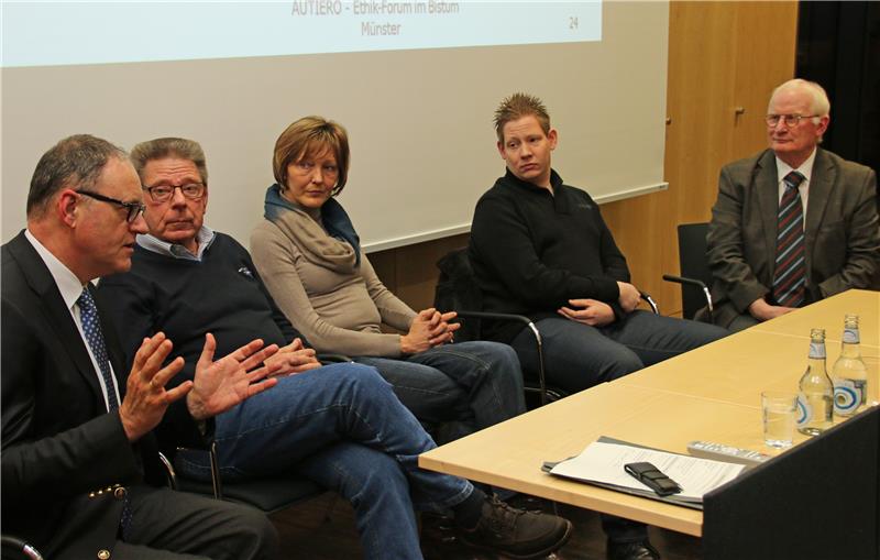 Vier Damen und Herren sitzen vor einem Tisch und diskutieren miteinander.