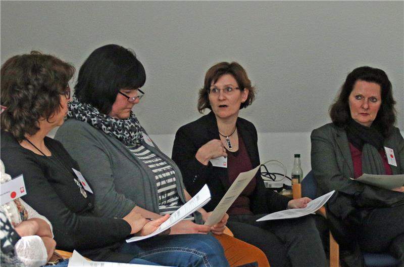 Eine Frau erzählt drei anderen Frauen etwas.