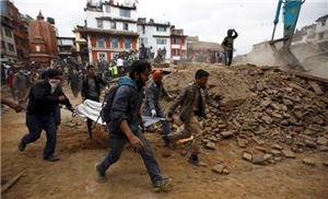 043-2015 Erdbeben Nepal Das Foto zeigt Menschen, die über einen Schuttberg laufen.