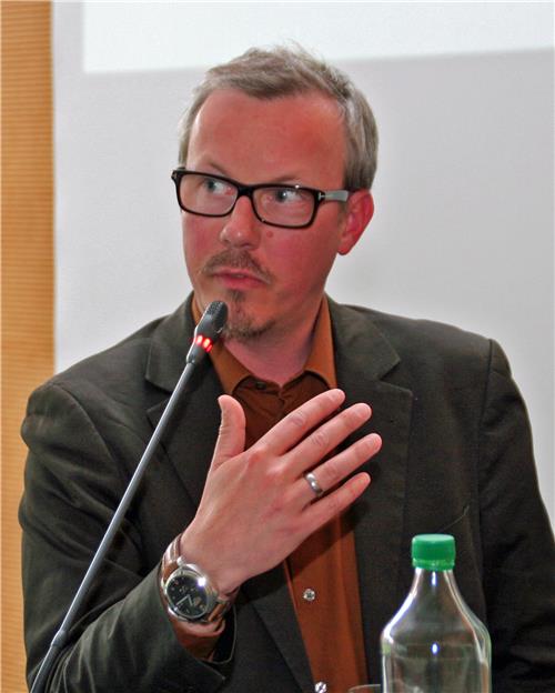 Auf dem Bild steht Professor Doktor Isfort am Rednerpult