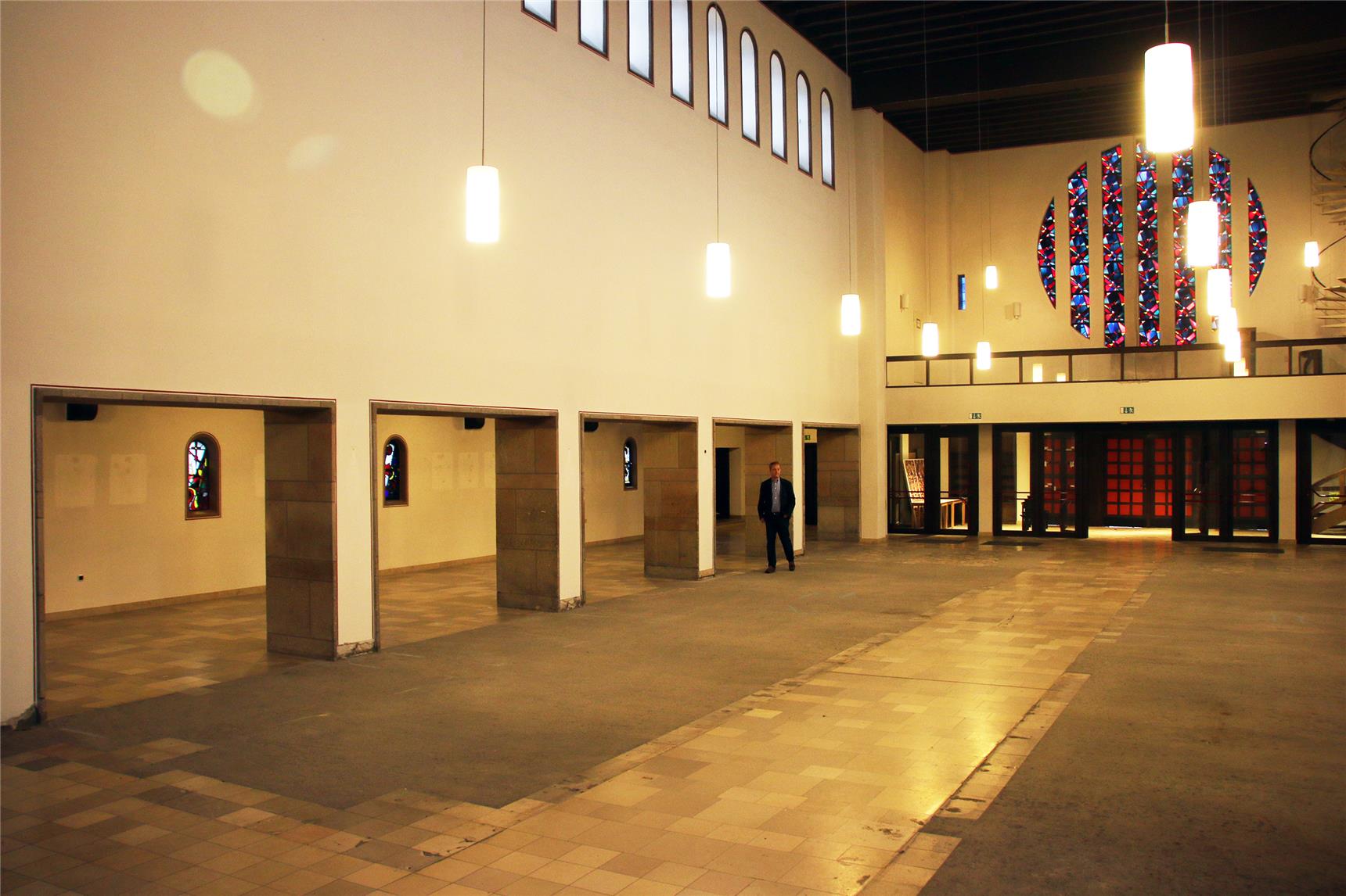 Das Bild zeigt einen Mann in einer leeren Kirche