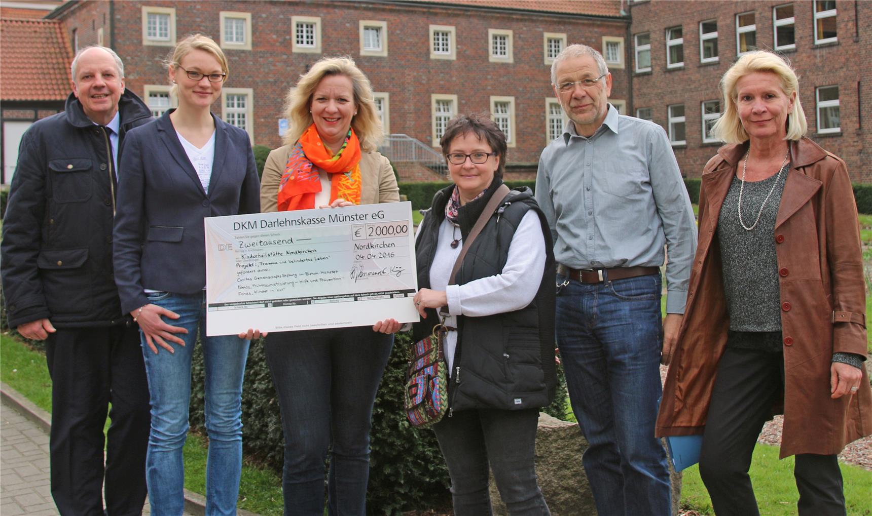 Ein Gruppenbild, auf dem ein Scheck überreicht wird.