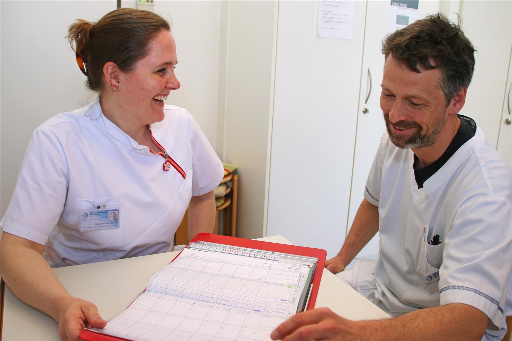 Zwei Menschen sitzen an einem Tisch.