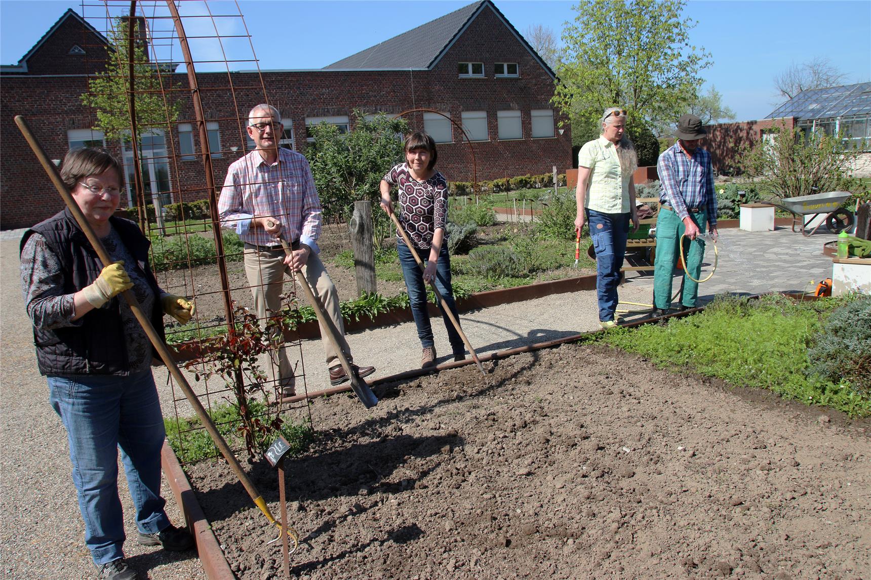 Fünf Personen pflegen tatkräftig den Garten.