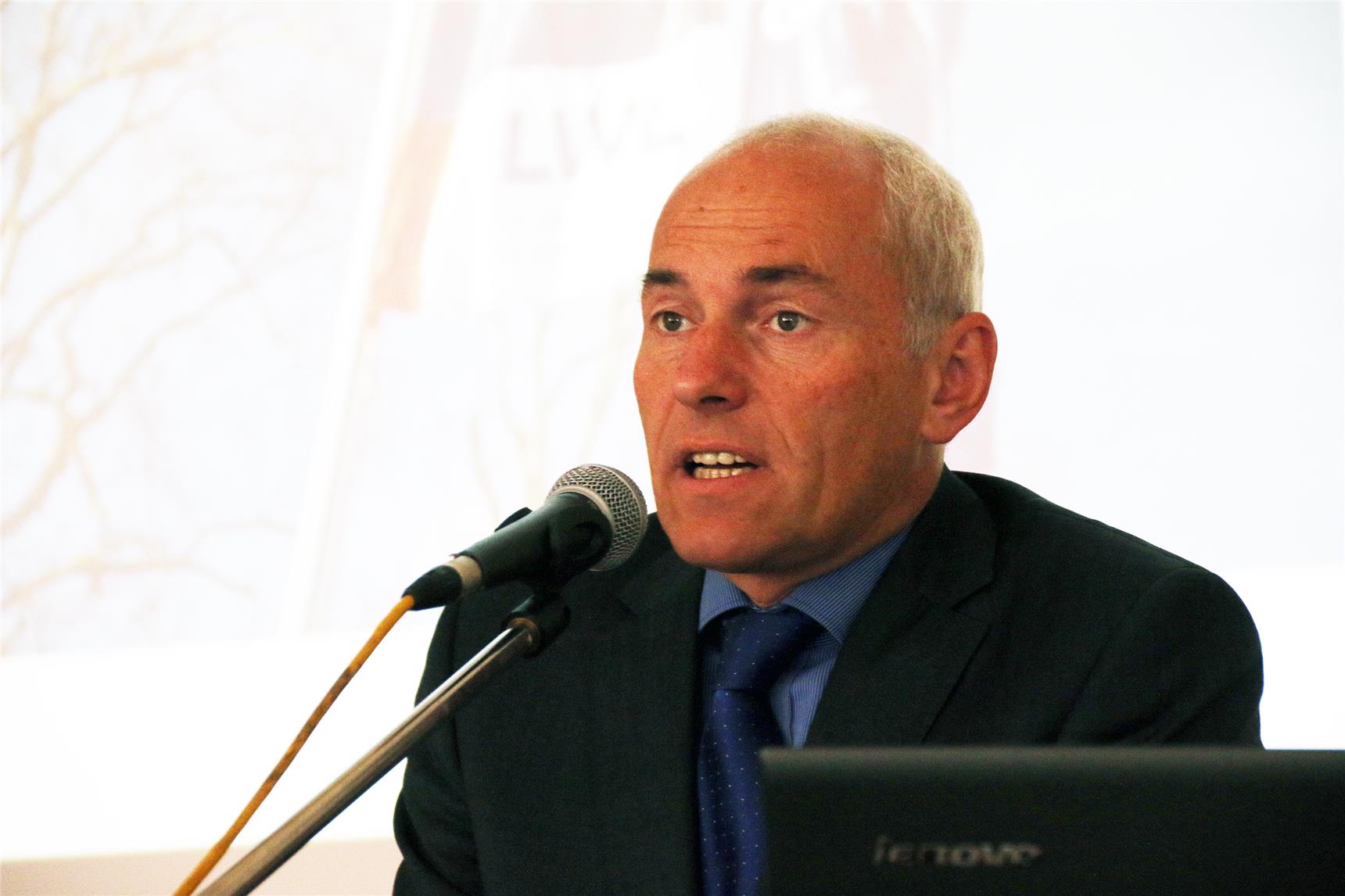 Ein Mann sitzt vor einem Mikrofon.