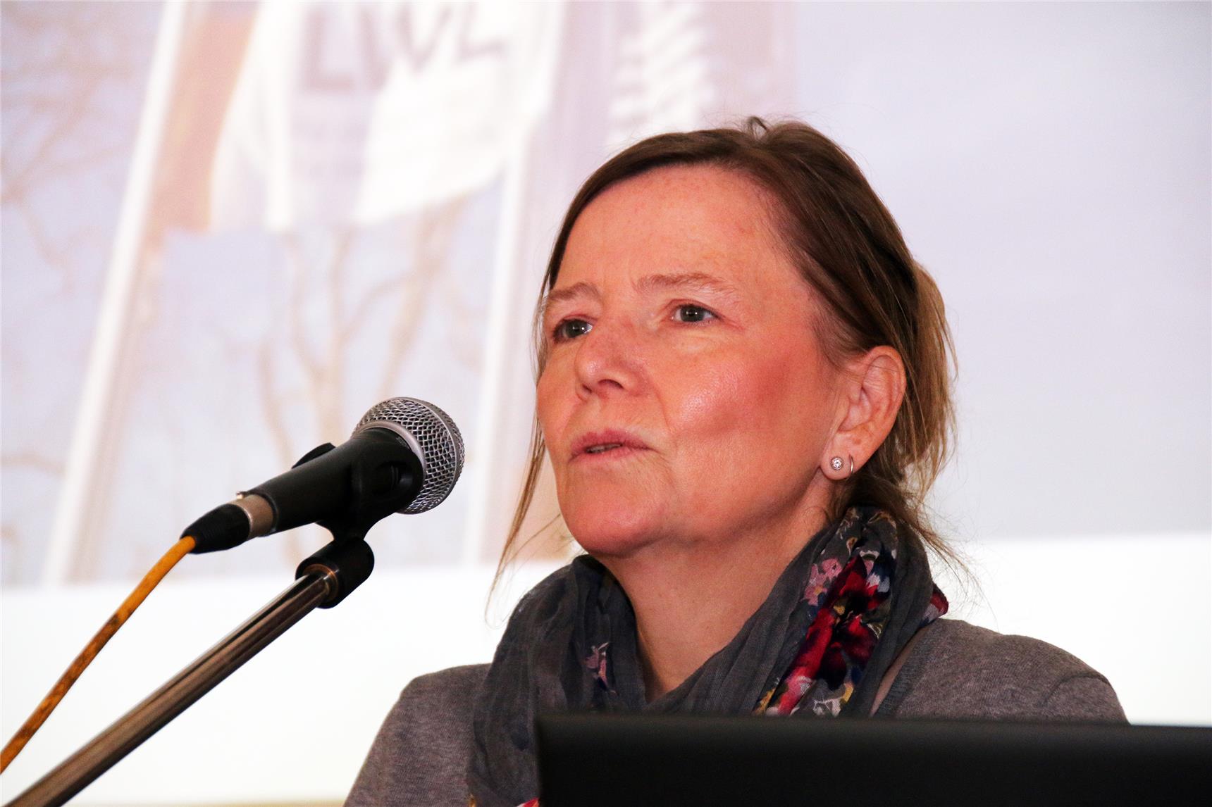 Eine Frau sitzt vor einem Mikrofon.