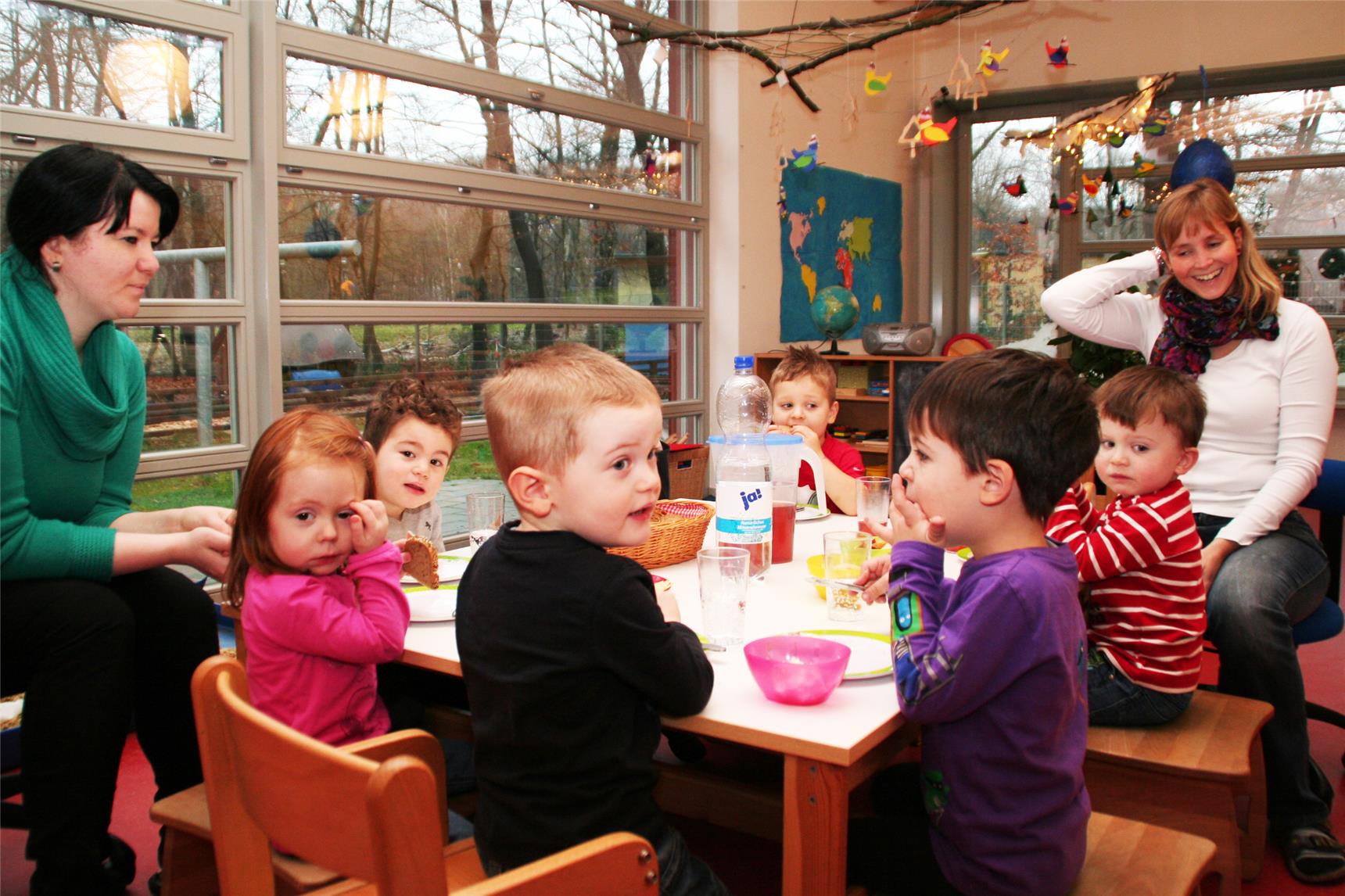 Das Bild zeigt eine Gruppe Kinder mit zwei Erzieherinnen.