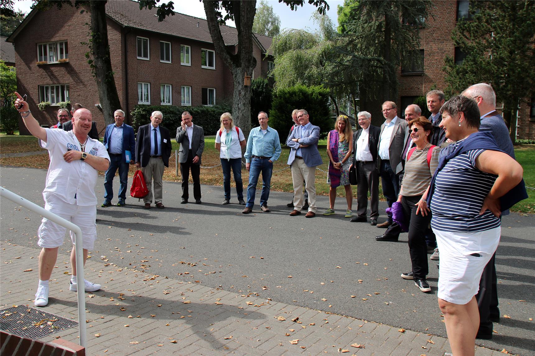 Das Foto zeigt eine Gruppe von Menschen im Halbkreis.