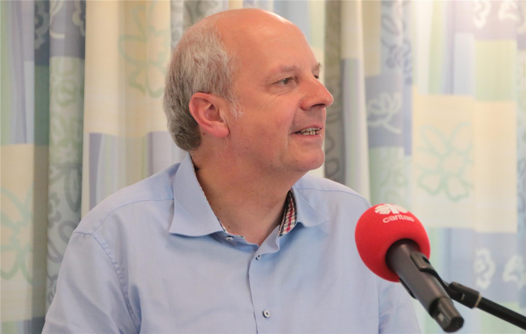 Ein Mann spricht am Mikrofon.