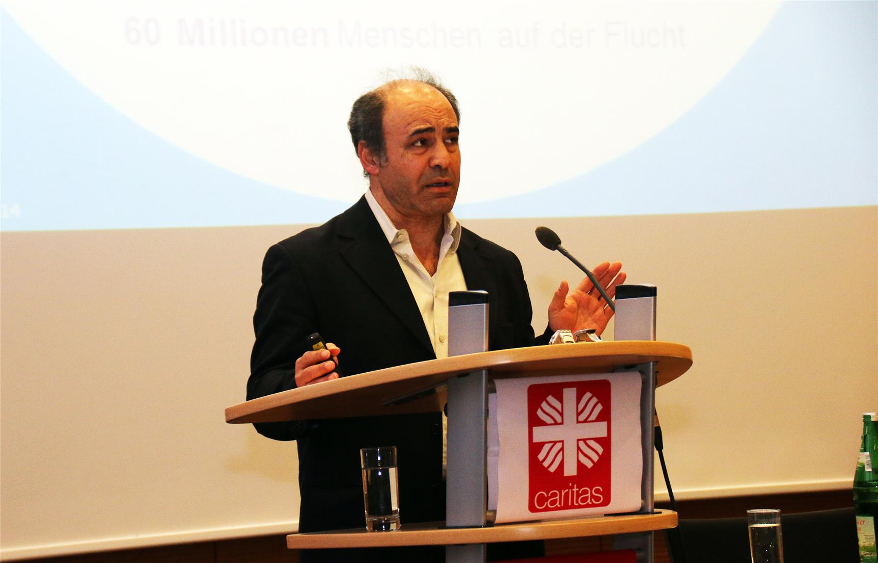 Auf dem Bild steht ein Mann am Rednerpult