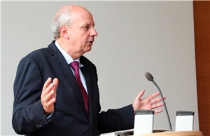 048-2017- Delegiertenversammlung Das Foto zeigt einen Redner an einem Pult vor einem weißen Hintergrund.