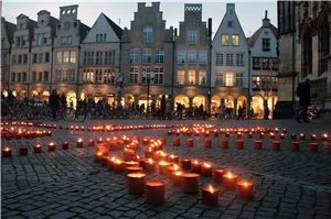 087-2017_1 Million Sterne Das Foto zeigt brennende Kerzen vor der Kulisse von Häusern.