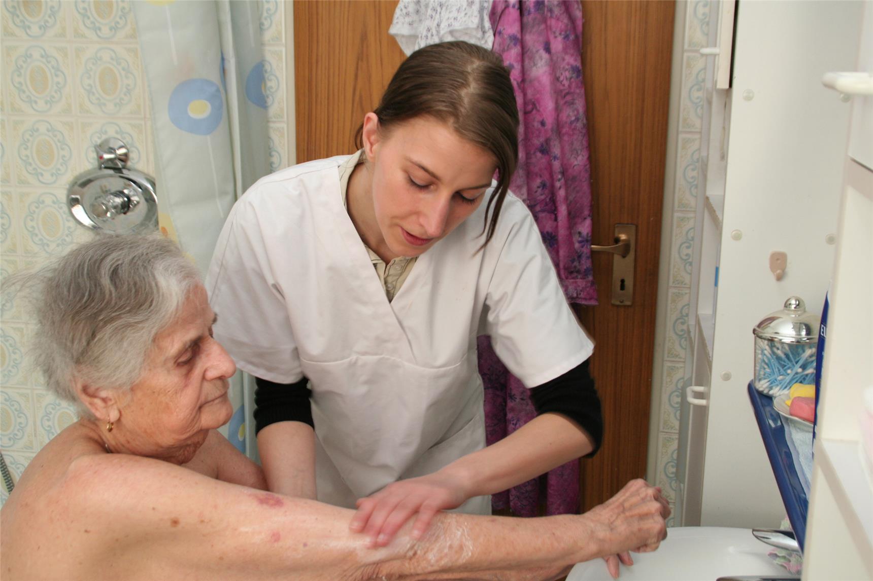 Eine Pflegerin hilft bei der Körperhygiene