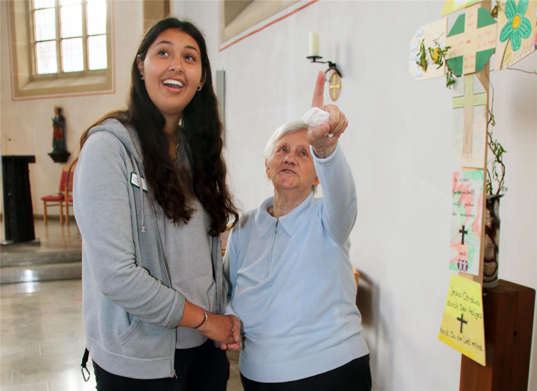 Eine junge und eine alte Frau stehen im Gespräch zusammen.