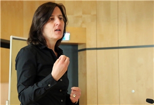 027-2019 Digitalisierung Kita Das Foto zeigt eine Frau, die mit einem Mikrofon eine Rede hält.